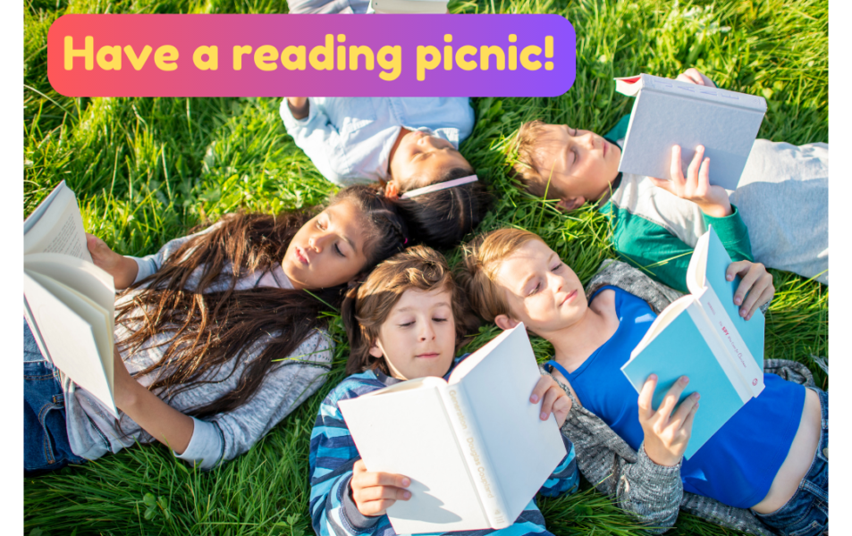 Kids reading and having a summer reading picnic while reading books in the grass.